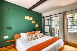 a bedroom with a green wall and a bed at Casa Altata Hotel Boutique in Mexico City