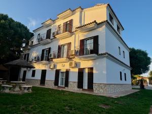 a large yellow and white building with a yard at Apartamentos Costa Trafalgar in Zahora