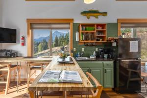 a kitchen with a wooden table and a refrigerator at Little Big Fish | Wifi, BBQ, AC ,Rainier View in Packwood