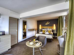 a hotel room with a bed and a table at Mercure Avignon Centre Palais des Papes in Avignon +60 photos