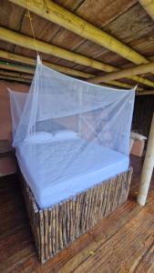 a bed with a plastic canopy on a wooden floor at Ecologic Mountain Cabin, amazing view in Santa Marta