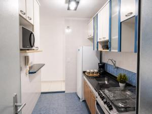 a small kitchen with a sink and a refrigerator at Ap 4 Hosp Autódromo Interlagos,Expo Transamérica mais Taxi a combinar in São Paulo