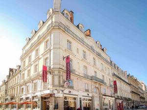 a large white building with red signs on it at Mercure Rennes Centre Place Bretagne in Rennes