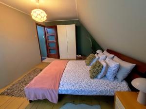 a bedroom with a large bed with pillows at Cherry Tree Cozy Rooms in Gdańsk +3 photos