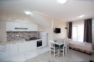 a kitchen and dining room with a table and a bed at Apartmani Čukić Rafailovići in Budva