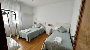 a bedroom with two beds and a window at AMANECER ZEN in Argés
