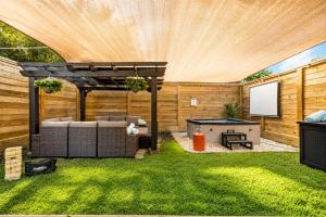 a backyard with a pergola and a table with a screen at Downtown Luxe Retreat - King Bed, Pool, Pong, Billiards, Grill & FREE Coffee in Houston