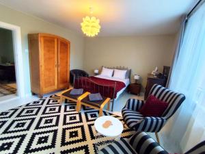 a bedroom with a bed and two chairs and a table at Cherry Tree Cozy Rooms in Gdańsk