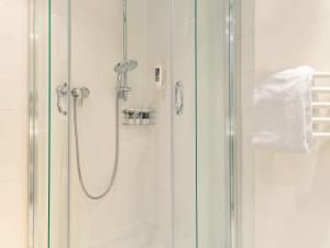 a bathroom with a shower with a glass door at Mercure Hotel Bad Oeynhausen City in Bad Oeynhausen +71 photos