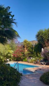 a swimming pool in a garden with trees and flowers at La Finca Blanca in Alora