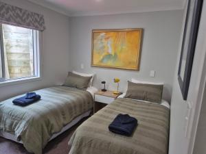 a bedroom with two beds and a window at Fairburn Hideaway in Cambridge