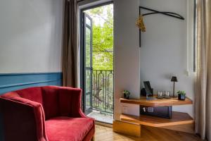 a living room with a red chair and a window at Casa Altata Hotel Boutique in Mexico City