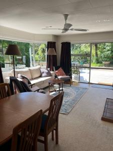 a living room with a table and a couch at Secluded Bush Retreat in Hikuai