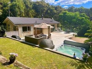 a backyard with a swimming pool and a house at Secluded Bush Retreat in Hikuai