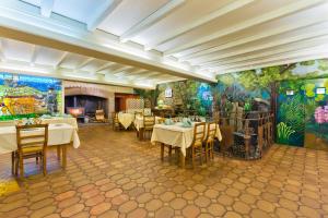 a restaurant with tables and chairs and a mural at Hôtel Restaurant Au Pont de Raffiny in Saint-Romain
