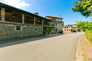 an empty road in front of a stone building at Hôtel Restaurant Au Pont de Raffiny in Saint-Romain