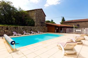 a swimming pool with chaise lounge chairs and a house at Hôtel Restaurant Au Pont de Raffiny in Saint-Romain