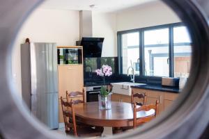 a kitchen with a table and a kitchen with a refrigerator at Quinta do Olival Amarante in Gatão