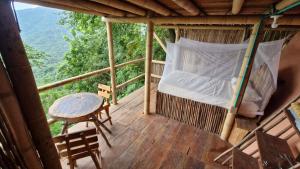a room with a bed and a table on a deck at Ecologic Mountain Cabin, amazing view in Santa Marta