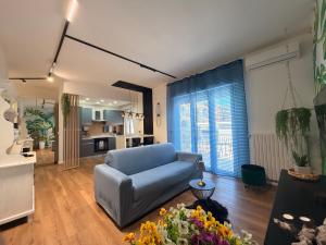 a living room with a blue couch and a kitchen at Lo Snodo Apartments cucina e parcheggio in Pomigliano dʼArco