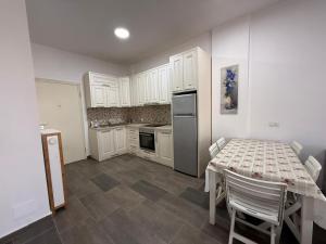 a kitchen with a table and a kitchen with white cabinets at Beach Garden Home, Lalzi Bay in Draç
