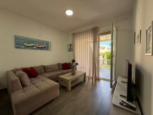 a living room with a couch and a television at Beach Garden Home, Lalzi Bay in Draç