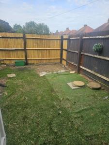 a backyard with a fence and a yard with grass at Ramsgate Cozy Home in Ramsgate +9 photos