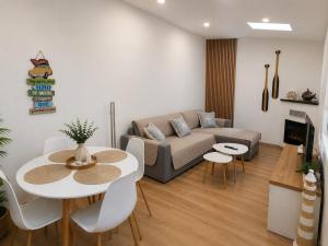 a living room with a couch and a table and chairs at APARTAMENTOS LA CAPILLA in Villanueva de Arosa