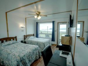 a hotel room with two beds and a mirror at Sea Breeze Motel in Ingonish