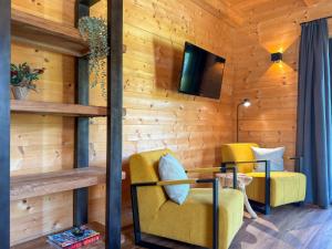 a room with wooden walls and two yellow chairs at Rattendorf 20A in Rattendorf