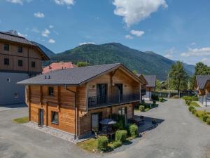 an aerial view of a log house with mountains in the background at Rattendorf 20A in Rattendorf