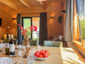 a table with a bowl of fruit and wine bottles at Rattendorf 20A in Rattendorf