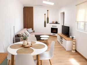 a white living room with a table and chairs at APARTAMENTOS LA CAPILLA in Villanueva de Arosa