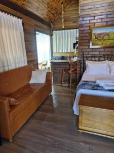a bedroom with a bed and a couch and a desk at Cabana Davos in Timbe do Sul