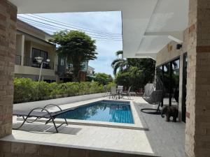 ein Swimmingpool mit einer Hängematte neben einem Haus in der Unterkunft BRW Samui in Bophut 