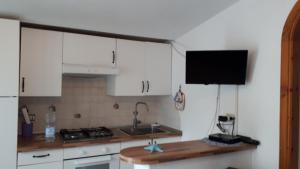 a kitchen with white cabinets and a sink at Villetta Lucia in Sperlonga