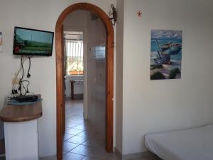 a room with a bed and a tv and a mirror at Villetta Lucia in Sperlonga
