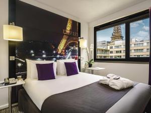 a bedroom with a bed with a view of the eiffel tower at Mercure Paris Centre Tour Eiffel in Paris +117 photos