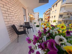 a balcony with flowers and a table and chairs at Lo Snodo Apartments cucina e parcheggio in Pomigliano dʼArco