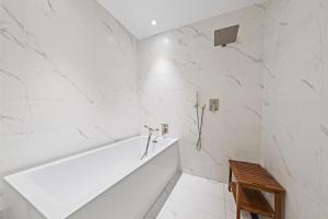 a bathroom with white marble walls and a tub at Amrit Resort - Bask in Rare Oceanfront Luxury with Stunning Views in Riviera Beach