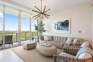 a living room with a couch and a chandelier at Amrit Resort - Bask in Rare Oceanfront Luxury with Stunning Views in Riviera Beach +19 photos