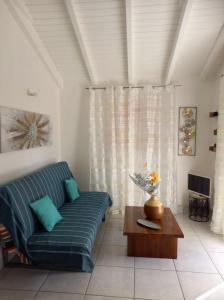 a living room with a blue couch and a table at O baobab in Saint-François +1 photo