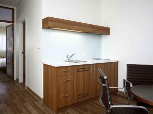a kitchen with a sink and a table in a room at Novotel Canberra in Canberra +149 photos