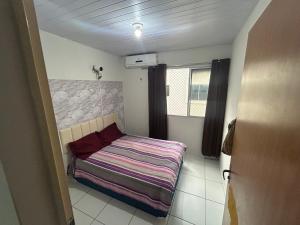 a small bedroom with a bed and a window at Ap Turquesa in Teresina