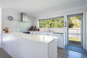 a kitchen with white counters and a large window at Pohara Retreat in Pohara +7 photos