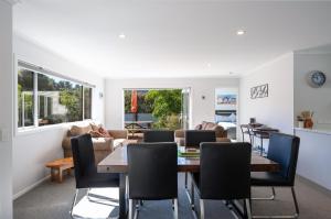 a dining room and living room with a table and chairs at Pohara Retreat in Pohara