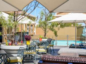 a patio with tables and chairs and a pool at Mercure Hotel Bedfordview in Johannesburg
