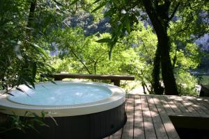 a hot tub sitting on a deck in a garden at Prehistoric Lodge in Vallon-Pont-dʼArc