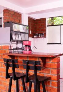 a kitchen with a brick wall and two chairs at Munay Wasy Carhuaz in Carhuaz