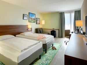 Mercure Stuttgart Sindelfingen an der Messe في شيندلفينجن: غرفة فندق بها سريران ومكتب